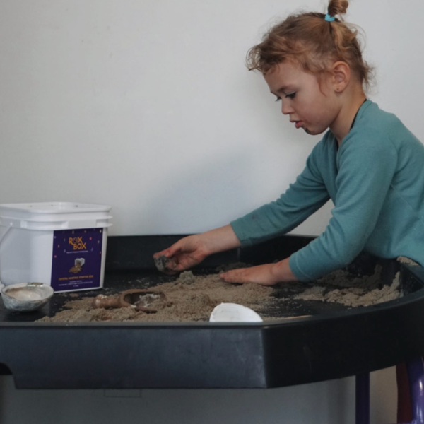 child plays with roxbox crystal mining bucket in sensory pit