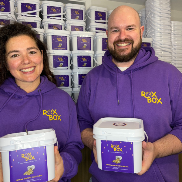 Fiona Nagy and Dan Watson stand in front of ROXBOX crystal mining buckets